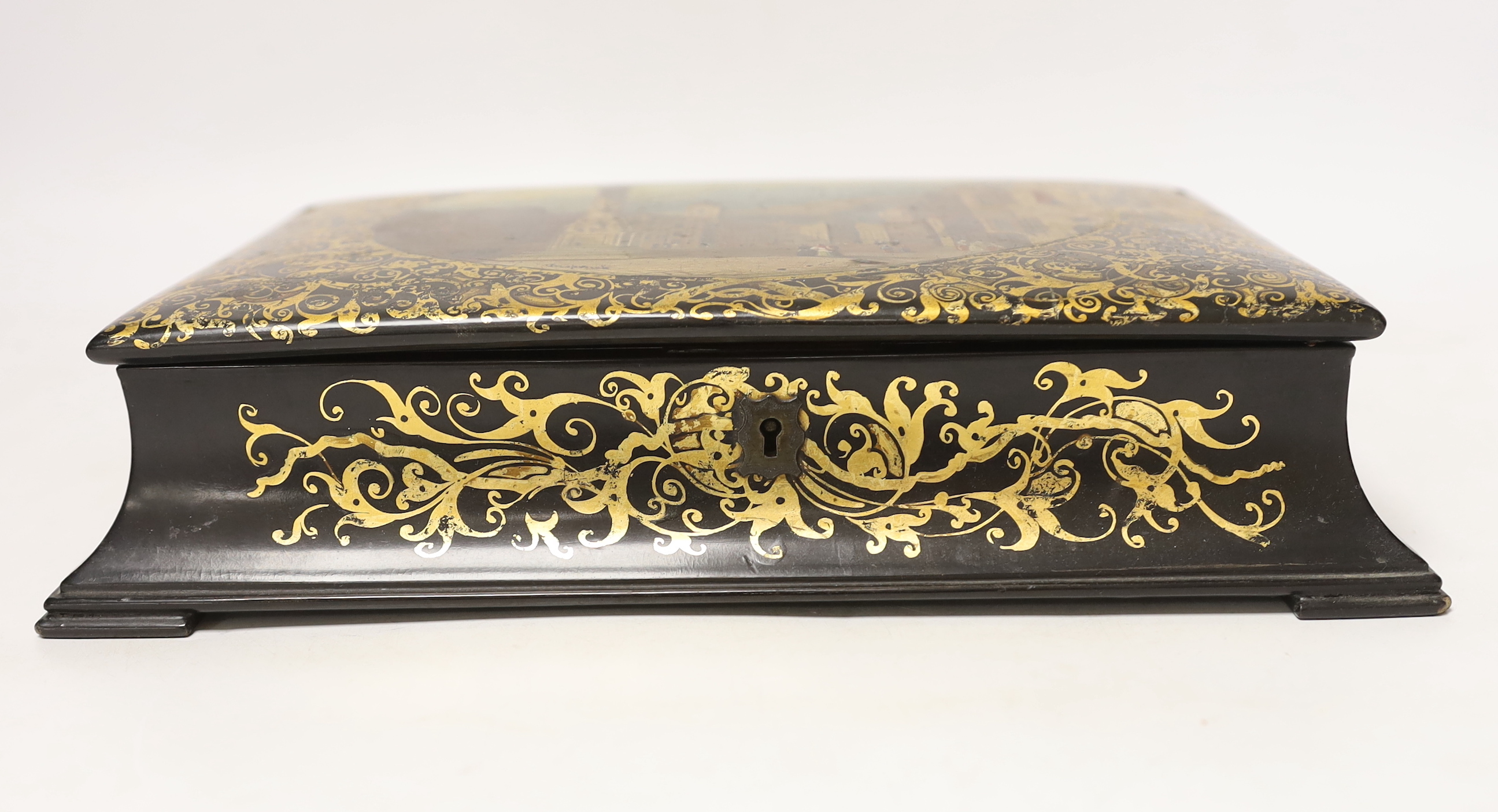 A Victorian stamped Jennens and Bettridge papier mache writing box, hand painted with a continental landscape with fitted watered silk interior, 27cm wide